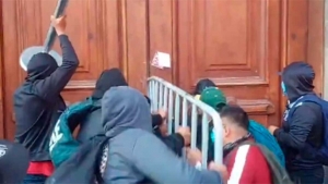 Normalistas de Ayotzinapa derriban puerta lateral de Palacio Nacional e intentan entrar